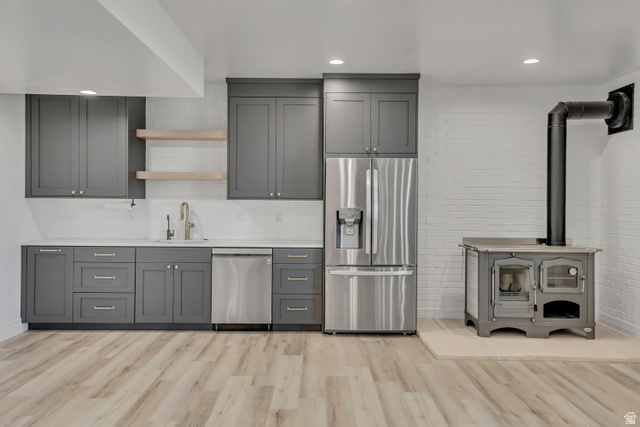 1720 Hillcrest Circle Mapleton, UT 84664 - Photo 71 of 116 Kitchen with gray cabinets, open shelves, stainless steel appliances, a wood stove, and light wood-type flooring