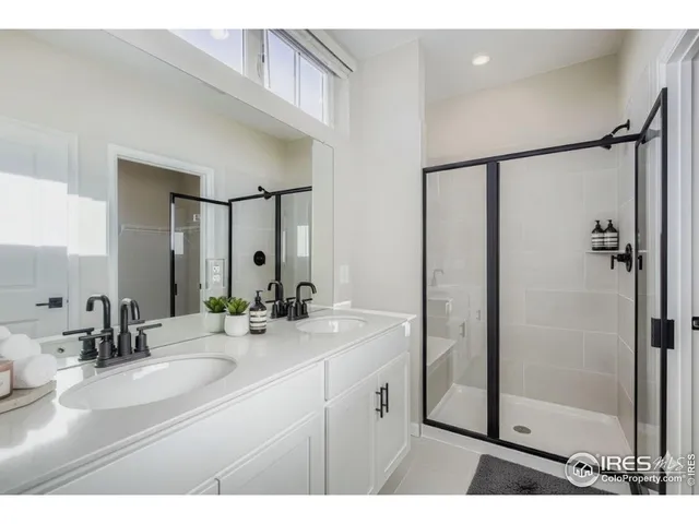 a bathroom with a double vanity sink mirror and shower