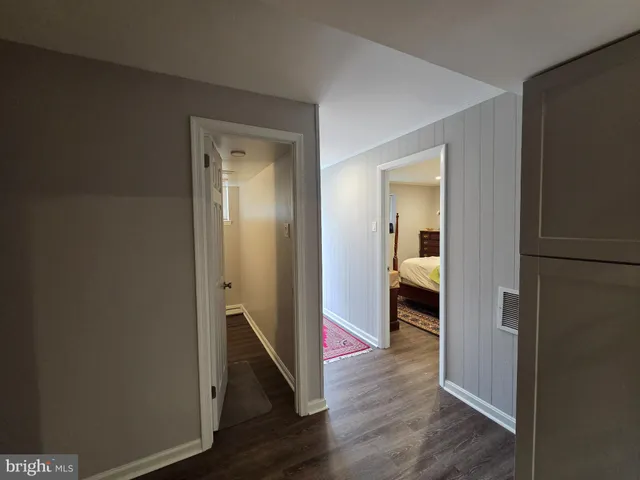 a view of a hallway with wooden floor and closet