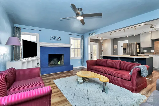 a living room with furniture a flat screen tv and a fireplace