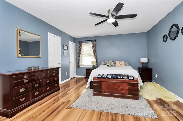 a spacious bedroom with a bed and a dresser