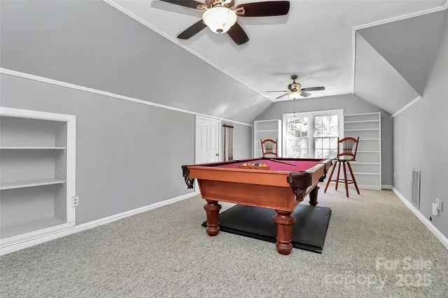 a room with pool table and windows