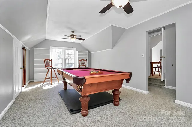 a room with pool table and windows