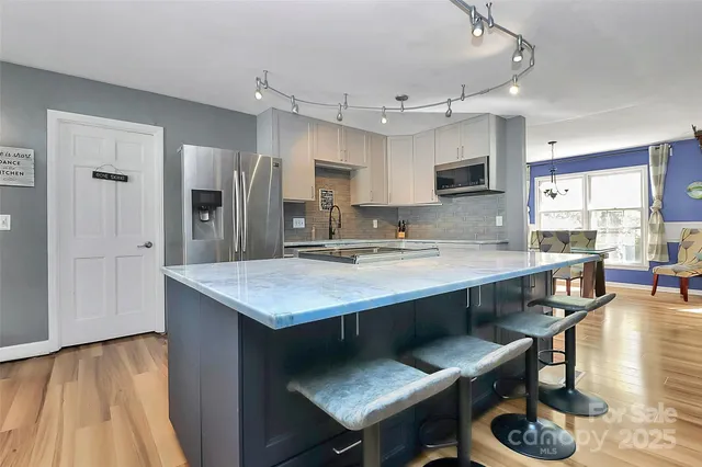 a kitchen with a table chairs sink and cabinets