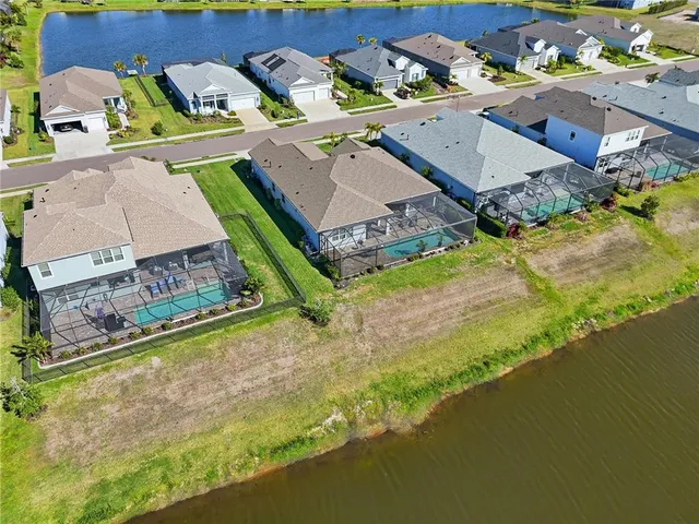 an aerial view of a house with a garden and lake view