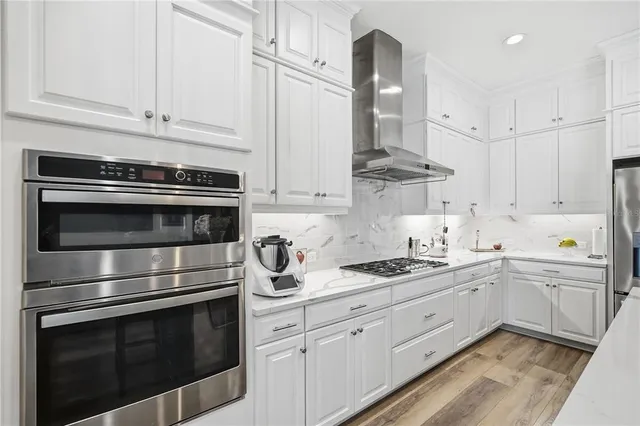 a kitchen with stainless steel appliances white cabinets and a stove a oven