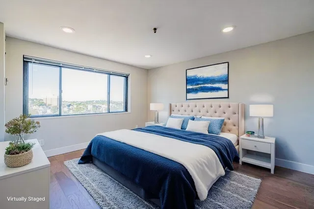 a bedroom with a large bed and a potted plant