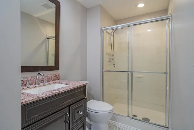 a bathroom with a granite countertop sink toilet and shower