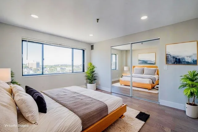 a bedroom with a large bed and a potted plant