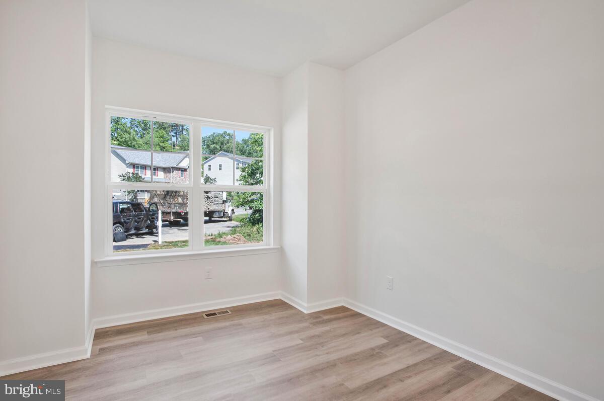 404 Warwick Place Edgewater, MD 21037 - Photo 17 of 76 an empty room with wooden floor and windows