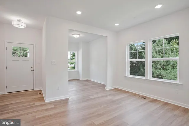 a large white kitchen with wooden floors and white walls