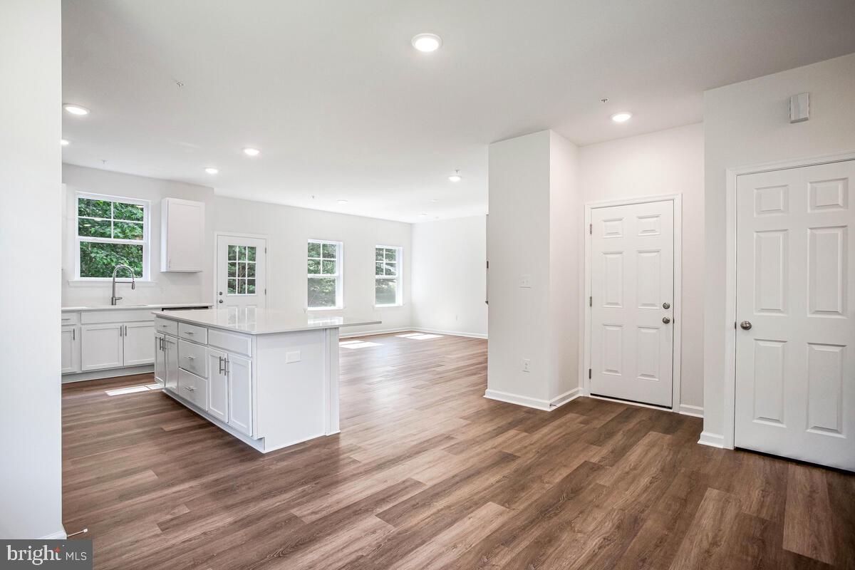 404 Warwick Place Edgewater, MD 21037 - Photo 7 of 76 a large white kitchen with wooden floors and white walls