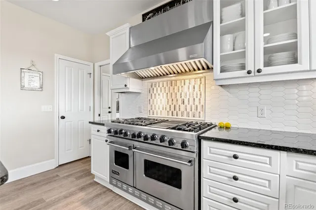 a kitchen with a stove and a wooden floor