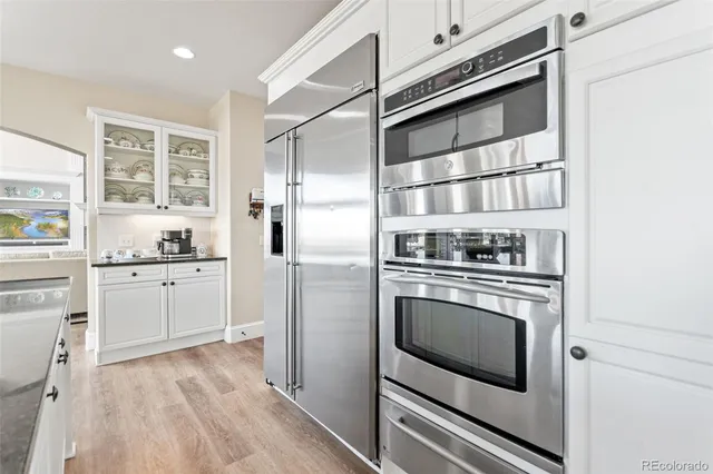 a kitchen with white cabinets and stainless steel appliances