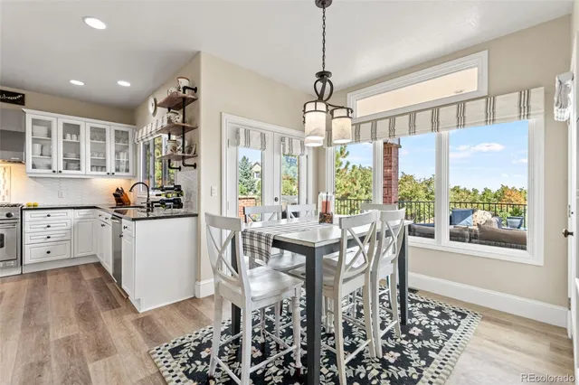 a view of a dining room and livingroom with furniture wooden floor a chandelier