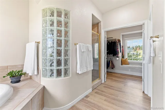 a view of a hallway with wooden floor and a living room