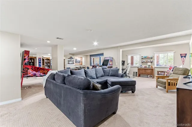 a living room with couches and a dining table with bookshelf