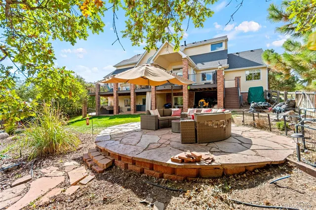 a view of a patio with table and chairs potted plants and a large tree