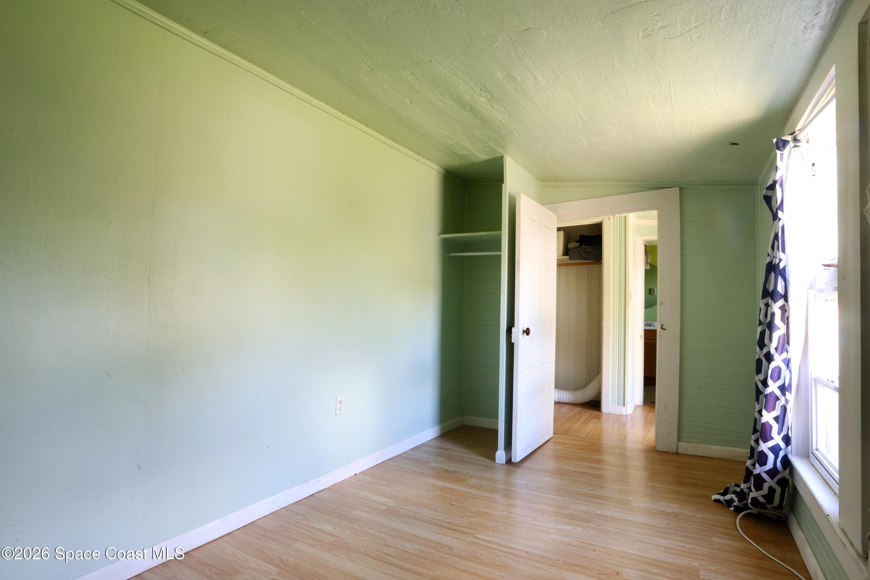 317 Pineda Street, Unit B Cocoa, FL 32922 - Photo 2 of 19 an empty room with wooden floor and a window