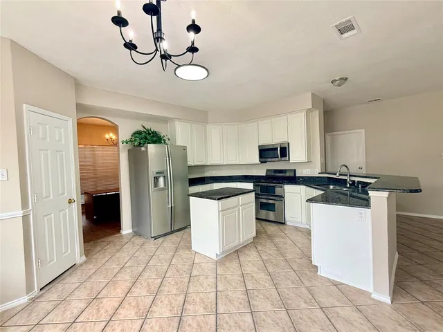 a kitchen with a refrigerator a microwave oven cabinets and a counter top space