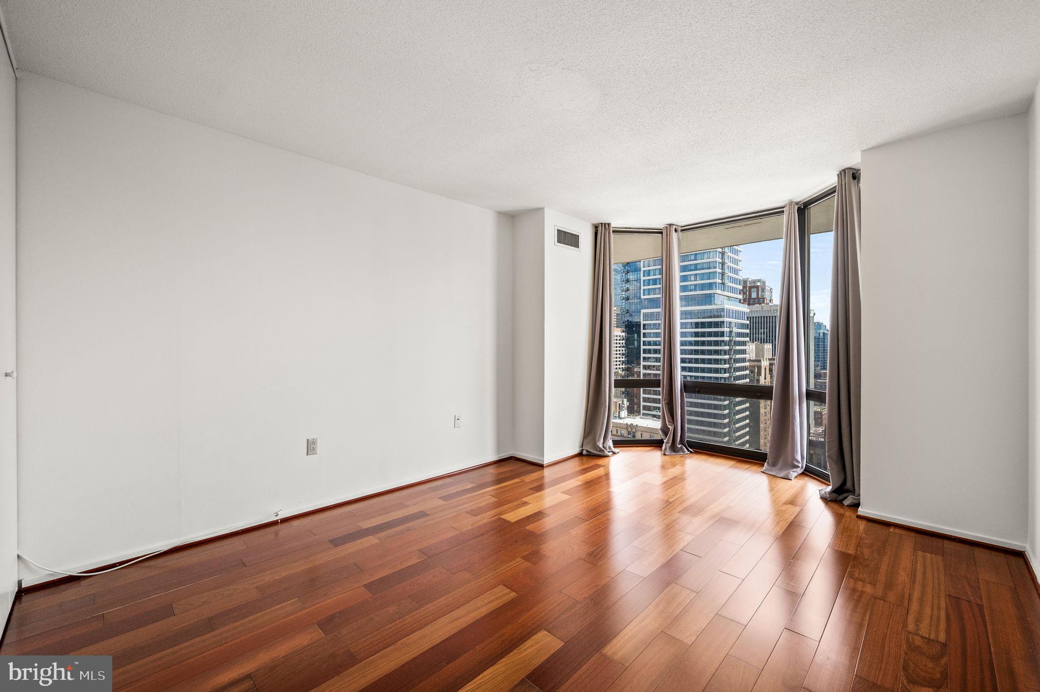 2020 Walnut Street, Unit 29D Philadelphia, PA 19103 - Photo 14 of 40 a view of an empty room with wooden floor and a window