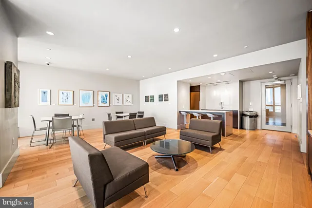a living room with furniture a flat screen tv and kitchen view
