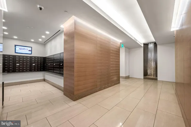 a view of an empty room with wooden floor and a bathroom