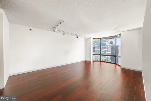 a view of an empty room with wooden floor