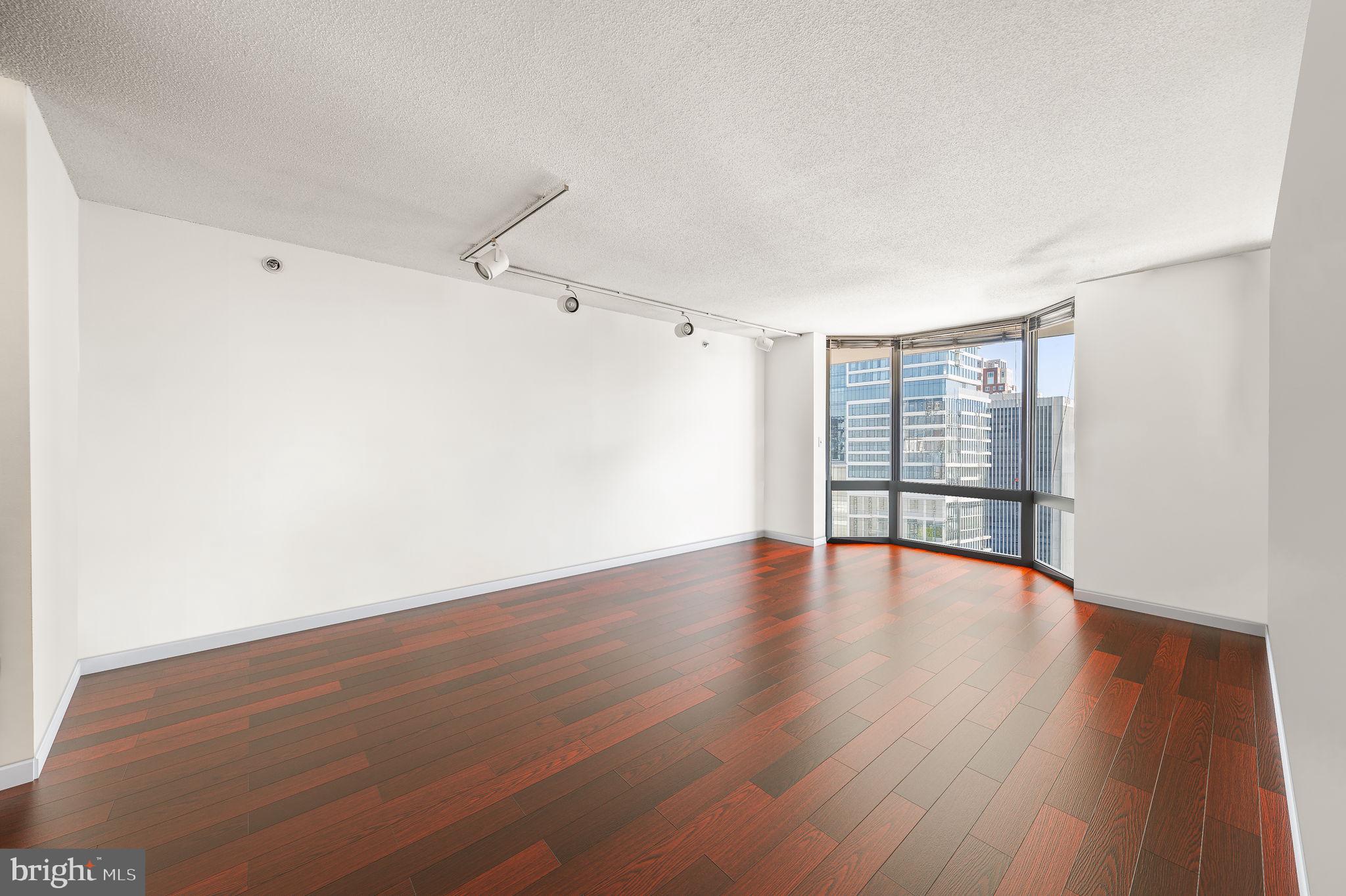 2020 Walnut Street, Unit 29D Philadelphia, PA 19103 - Photo 7 of 40 a view of an empty room with wooden floor and a window
