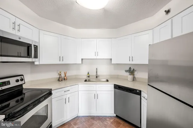 a kitchen with stainless steel appliances granite countertop white refrigerator stove a sink and dishwasher