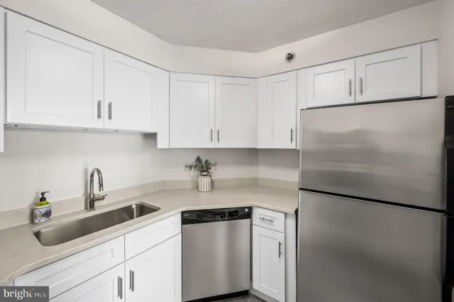 a kitchen with cabinets stainless steel appliances a sink and a counter top