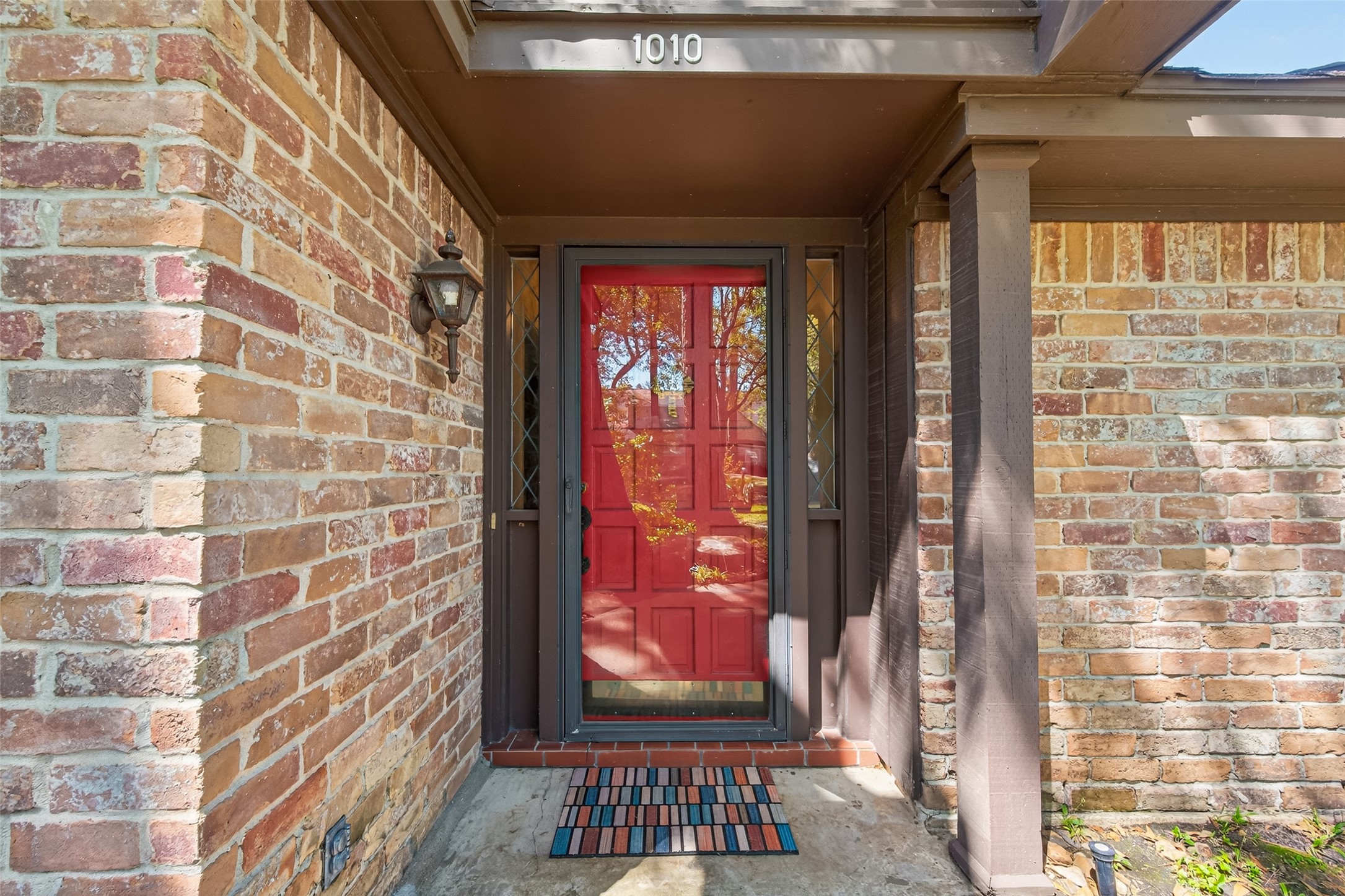 1010 Rhine Lane Houston, TX 77090 - Photo 2 of 30 a view of a brick house with a red door and wooden floor