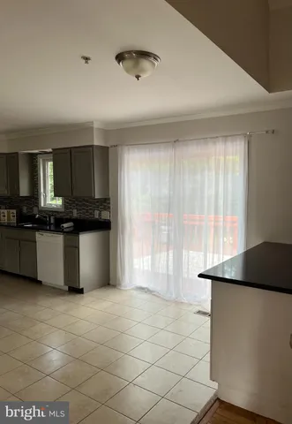 a kitchen with granite countertop a stove a sink a microwave and cabinets