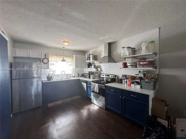 a kitchen with stainless steel appliances granite countertop a refrigerator a stove a sink dishwasher and wooden floor