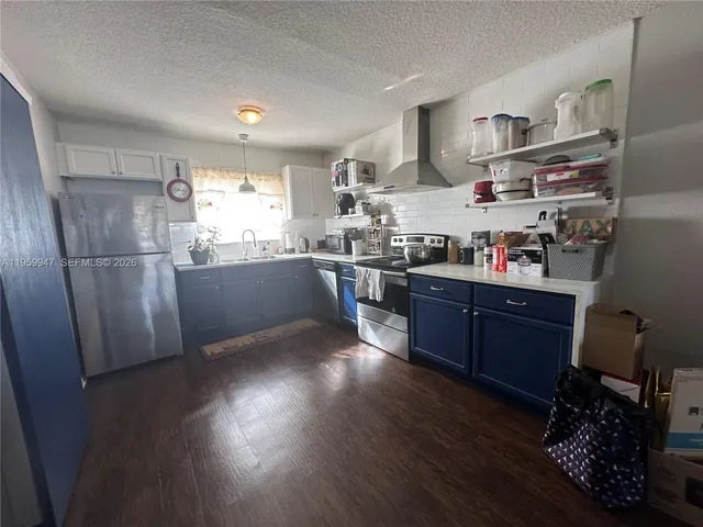 a room with a refrigerator and wooden floor