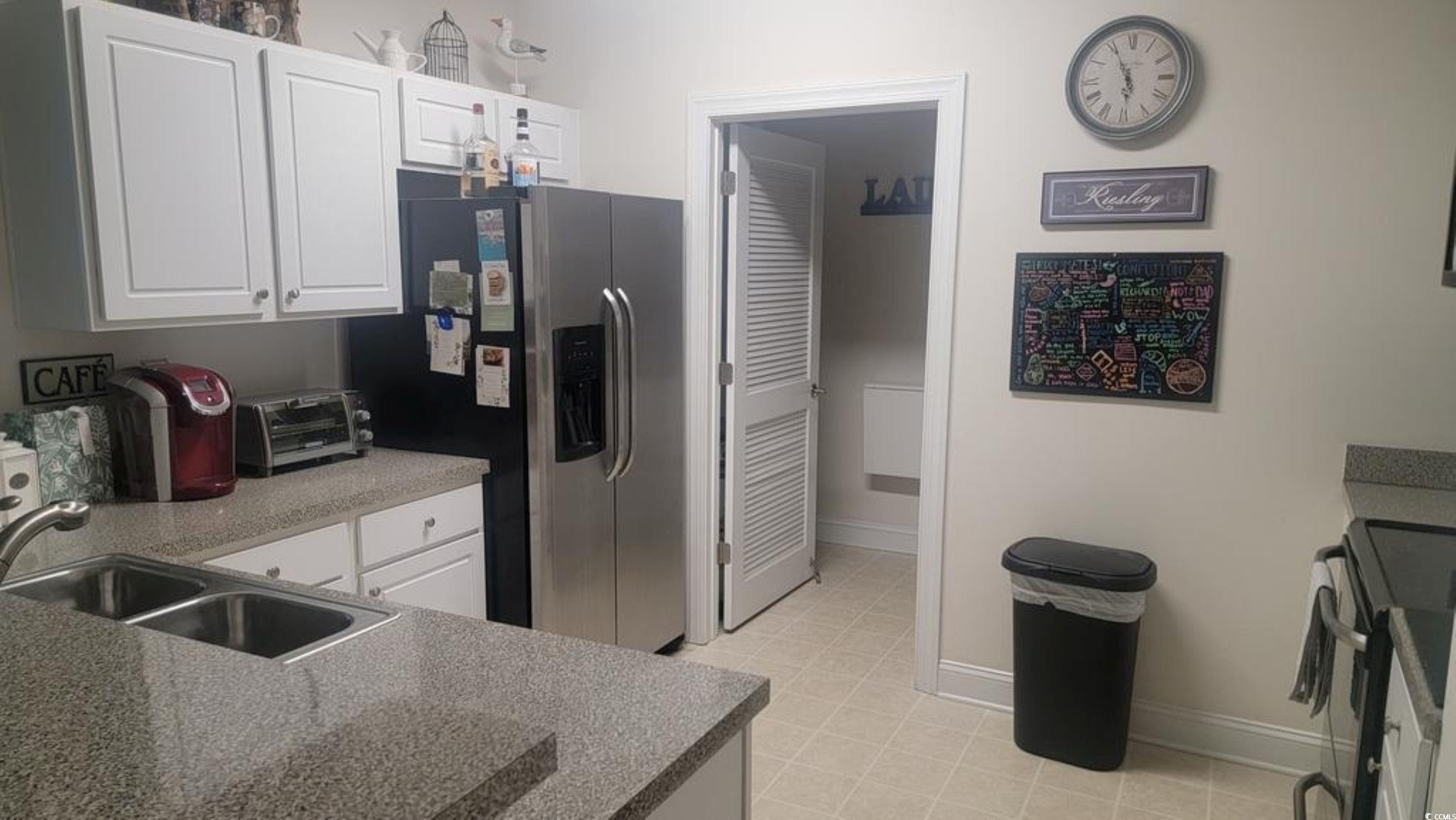 6000 Windsor Green Way, Unit 11202 Myrtle Beach, SC 29579 - Photo 5 of 10 Kitchen featuring stainless steel refrigerator with ice dispenser, black electric range oven, white cabinets, and a sink
