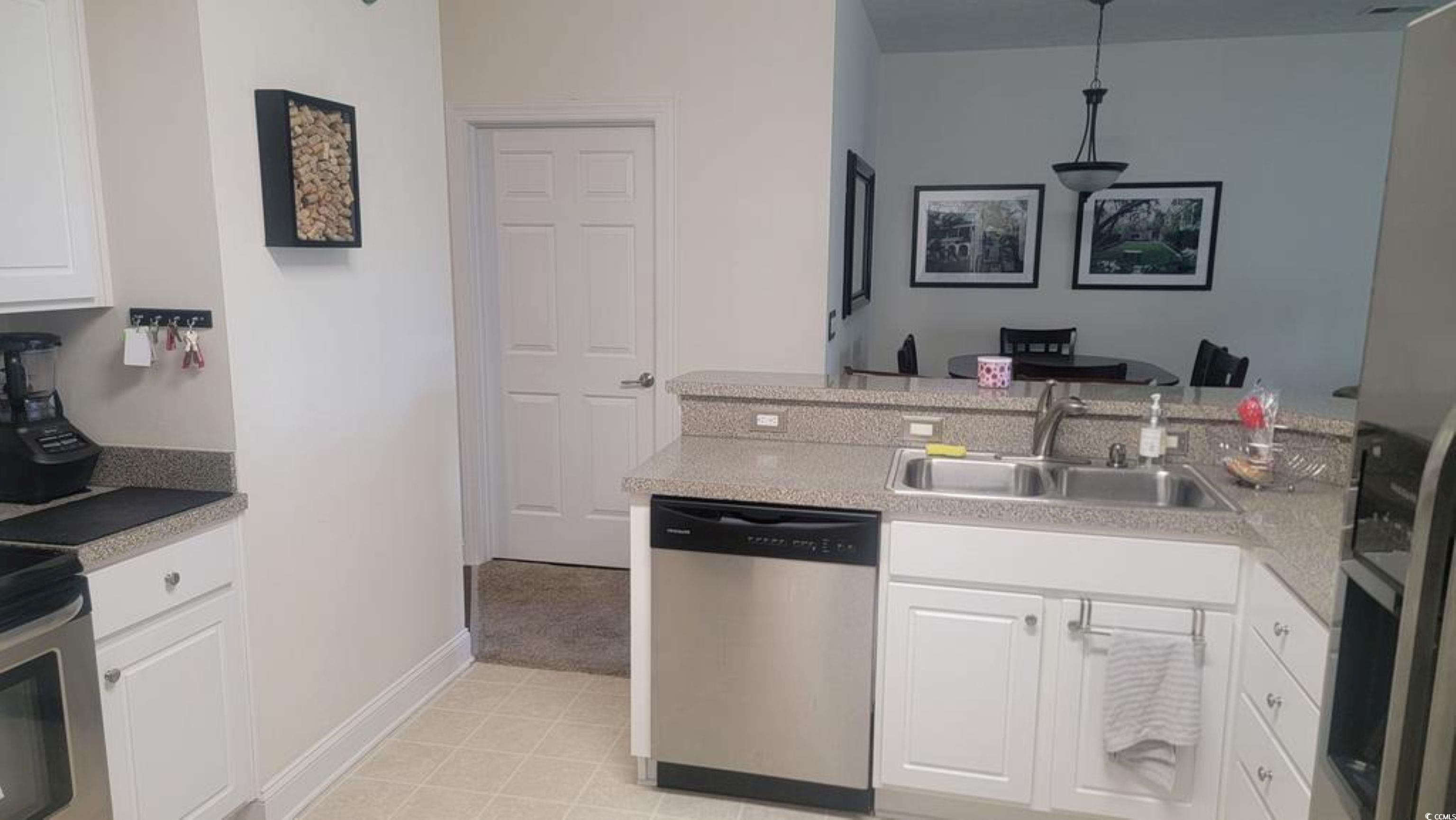 6000 Windsor Green Way, Unit 11202 Myrtle Beach, SC 29579 - Photo 6 of 10 Kitchen featuring a sink, dishwasher, light countertops, and white cabinetry