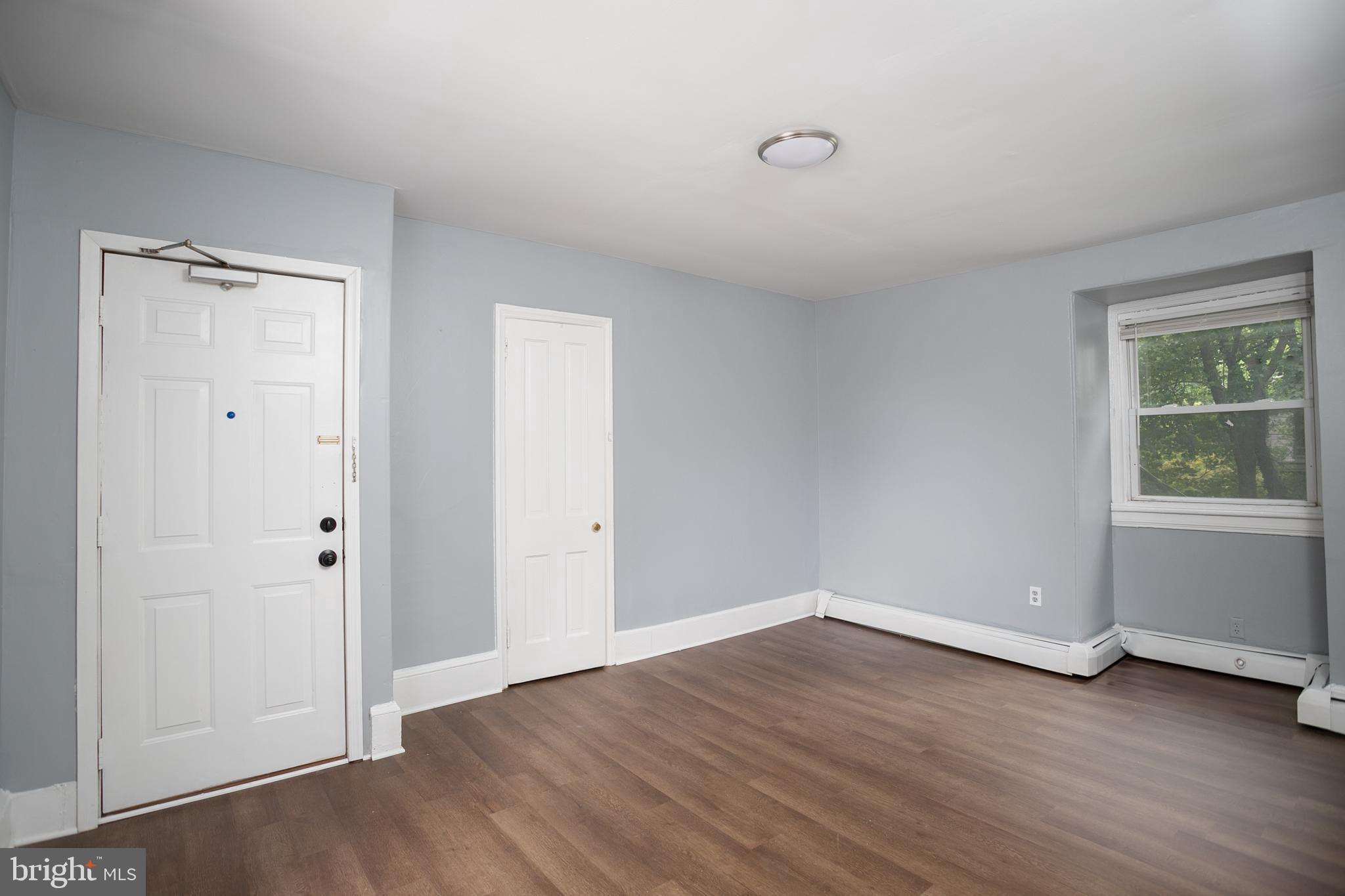 117 East Walnut Avenue, Unit E Merchantville, NJ 08109 - Photo 8 of 22 a view of an empty room with wooden floor and a window