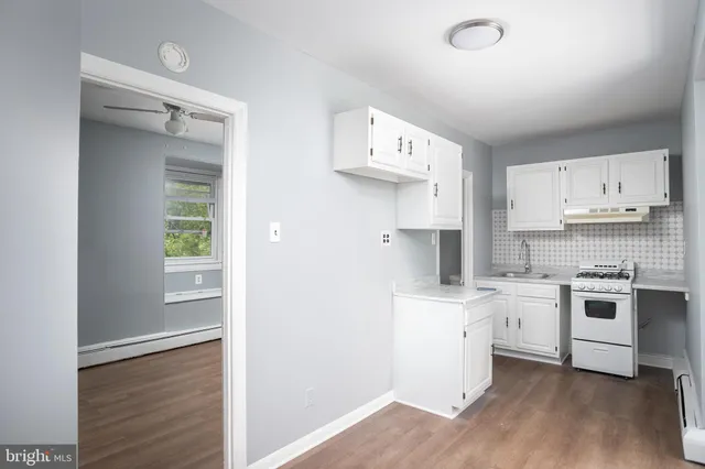 a kitchen with a sink a stove and cabinets