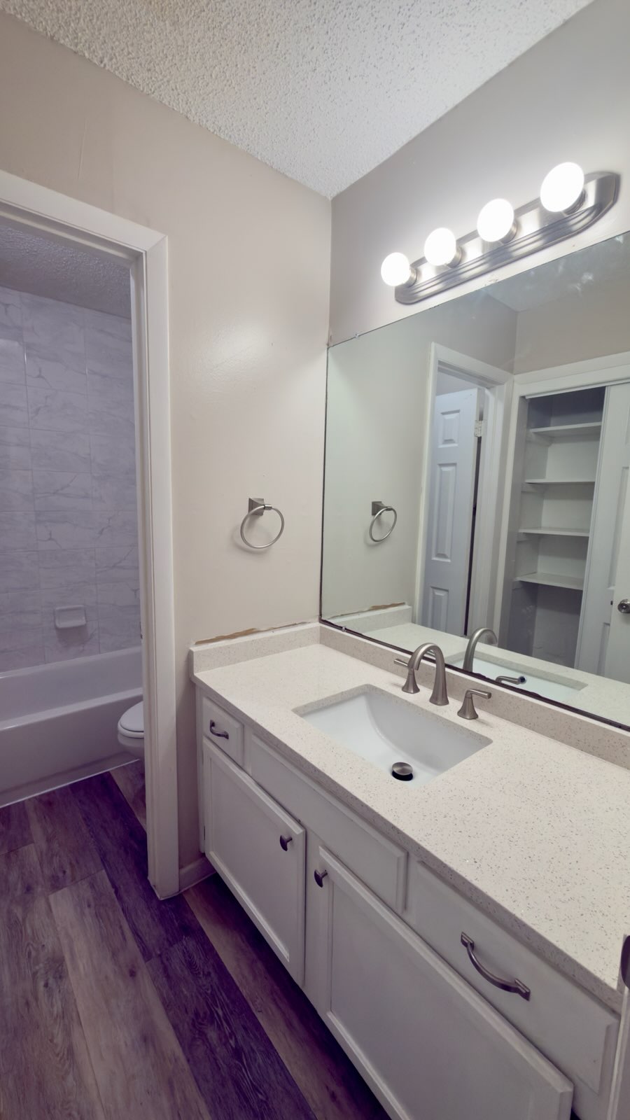 2306 Fuzz Fairway, Unit A Austin, TX 78728 - Photo 17 of 20 Bathroom featuring a white vanity with an integrated sink, a light-toned countertop, and wood-finish flooring