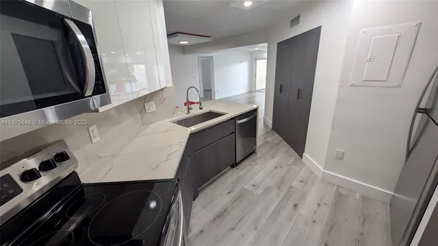 a kitchen with a refrigerator a sink and cabinets