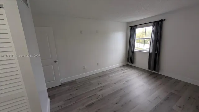 a hallway with wooden floor and windows