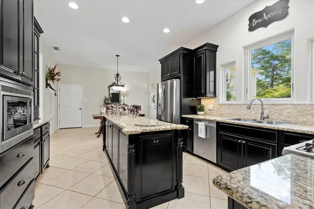 a kitchen with stainless steel appliances granite countertop a sink stove and refrigerator