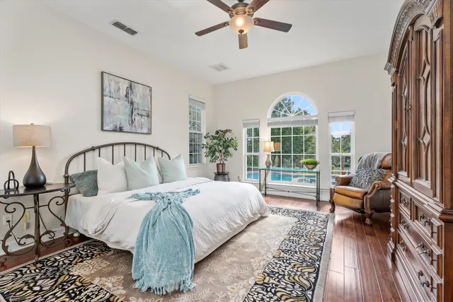 a large bedroom with a bed and a view of balcony