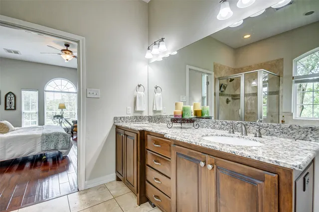 a bathroom with a granite countertop sink a light fixture and a mirror