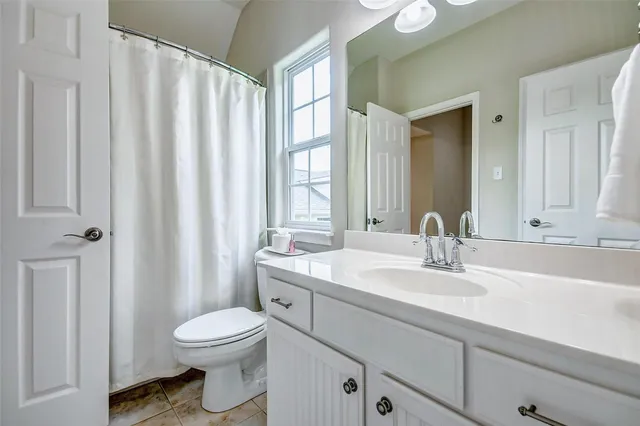 a bathroom with a toilet a sink a tub and mirror