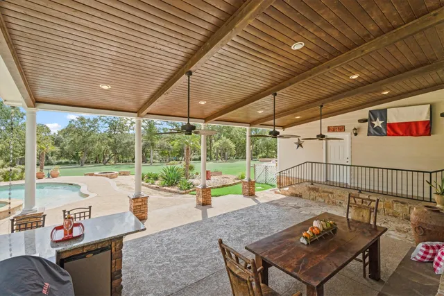 a view of a patio with a table and chairs under an umbrella