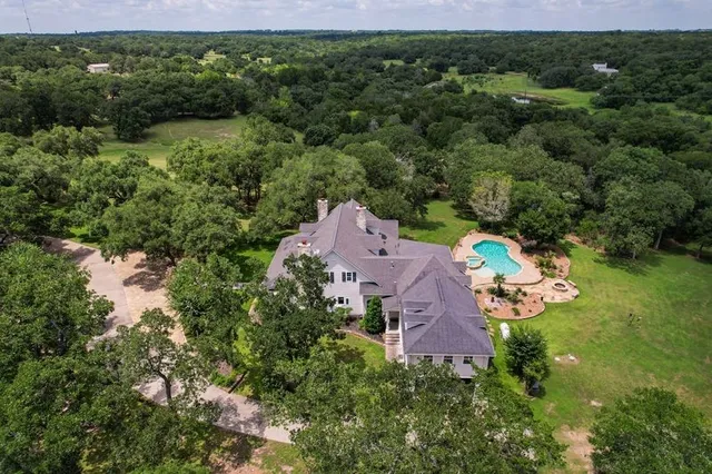 an aerial view of a house with a yard and lake view