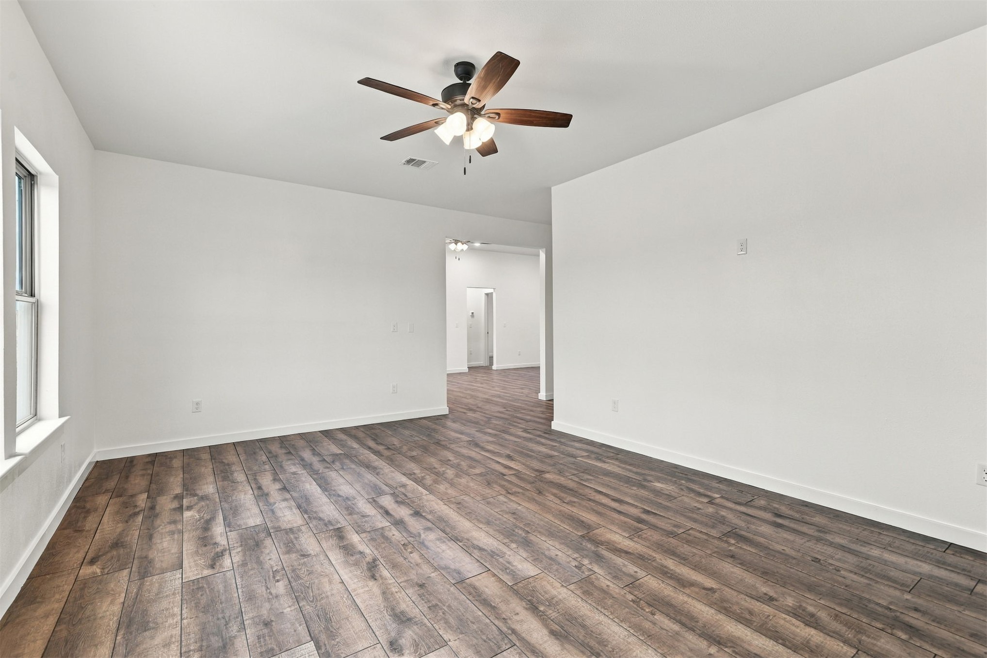 21 Redbird Lane Colbert, OK 74733 - Photo 12 of 27 Wood-finish flooring, white walls, and a ceiling fan with integrated lighting