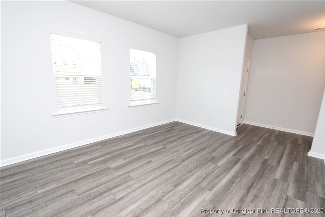 461 Grange Farm Place Raleigh, NC 27603 - Photo 6 of 50 an empty room with wooden floor and windows